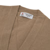 View 2 of product A Natural Cashmere Cardigan by Turnbull & Asser, light brown with a V-neckline, ribbed cuffs, and button closure, is neatly folded and displayed against a white background.