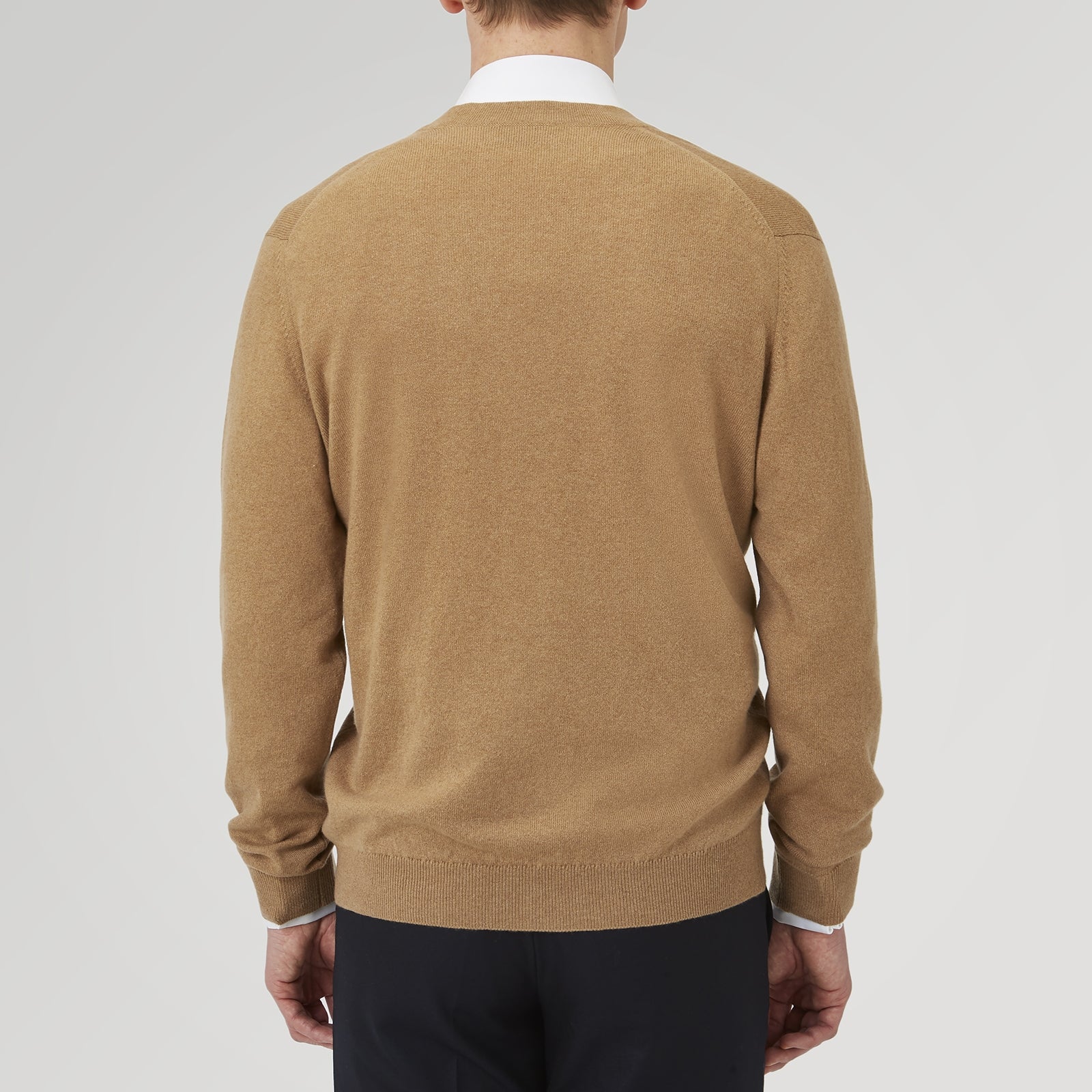 View 3 of product A Natural Cashmere Cardigan by Turnbull & Asser, light brown with a V-neckline, ribbed cuffs, and button closure, is neatly folded and displayed against a white background.