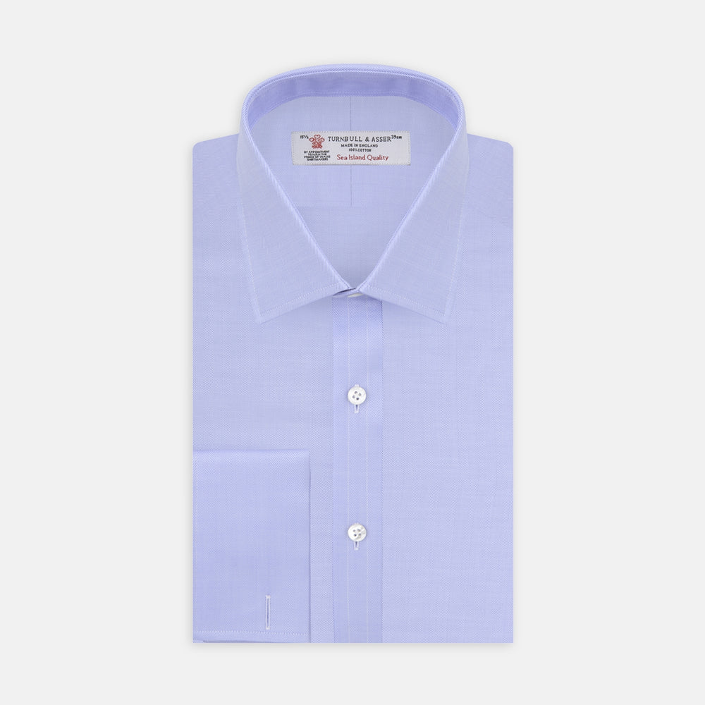 A Turnbull & Asser Light Blue Herringbone Sea Island Quality Cotton Shirt with T&A collar and double cuffs is neatly folded, label visible, and displayed against a plain white background.