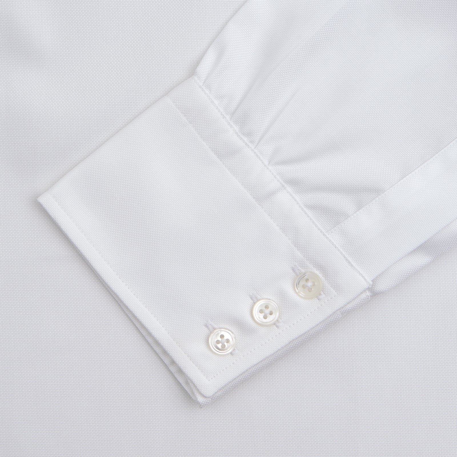 View 4 of product The Turnbull & Asser White Superfine Oxford Cotton Shirt features a T&A collar and 3-button cuffs, elegantly displayed against a light grey background.
