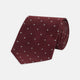 The Turnbull & Asser Burgundy and White Small Spot Herringbone Silk Tie, crafted from fine English silk, is shown rolled up on a plain white background.