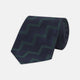 A modern essential, the Turnbull & Asser Navy and Forest Green Striped Zigzag Silk Tie features a bold navy and forest green zigzag pattern, elegantly displayed rolled on a crisp white background.