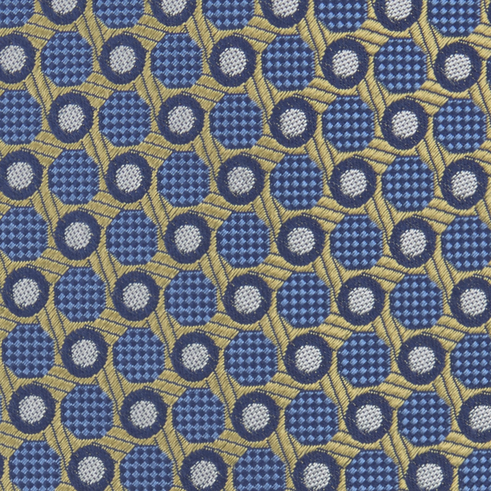 View 3 of product The Gold and Blue Circle and Spot Silk Tie by Turnbull & Asser features blue silk adorned with yellow and white circles and lines, rolled neatly on a light background—an elegant choice for complementing any office shirt.