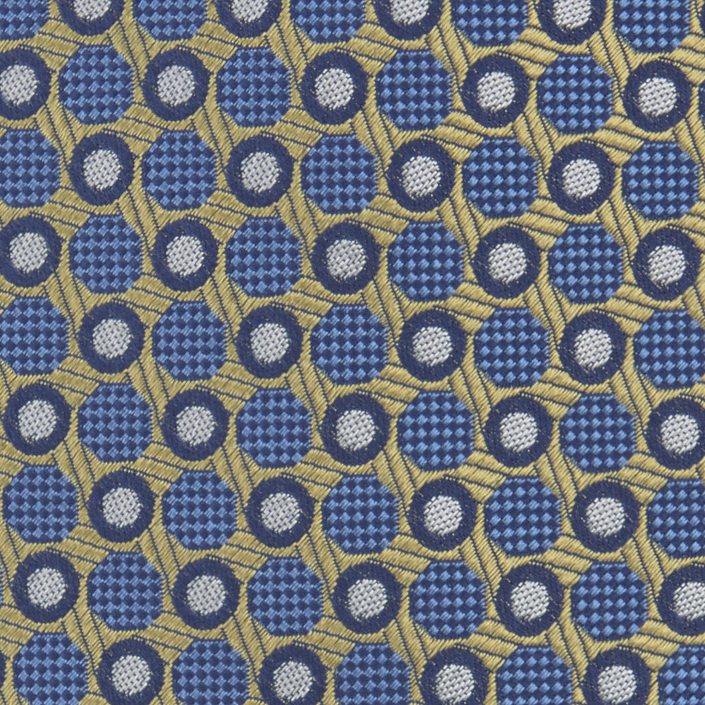 The Gold and Blue Circle and Spot Silk Tie by Turnbull & Asser features blue silk adorned with yellow and white circles and lines, rolled neatly on a light background—an elegant choice for complementing any office shirt.