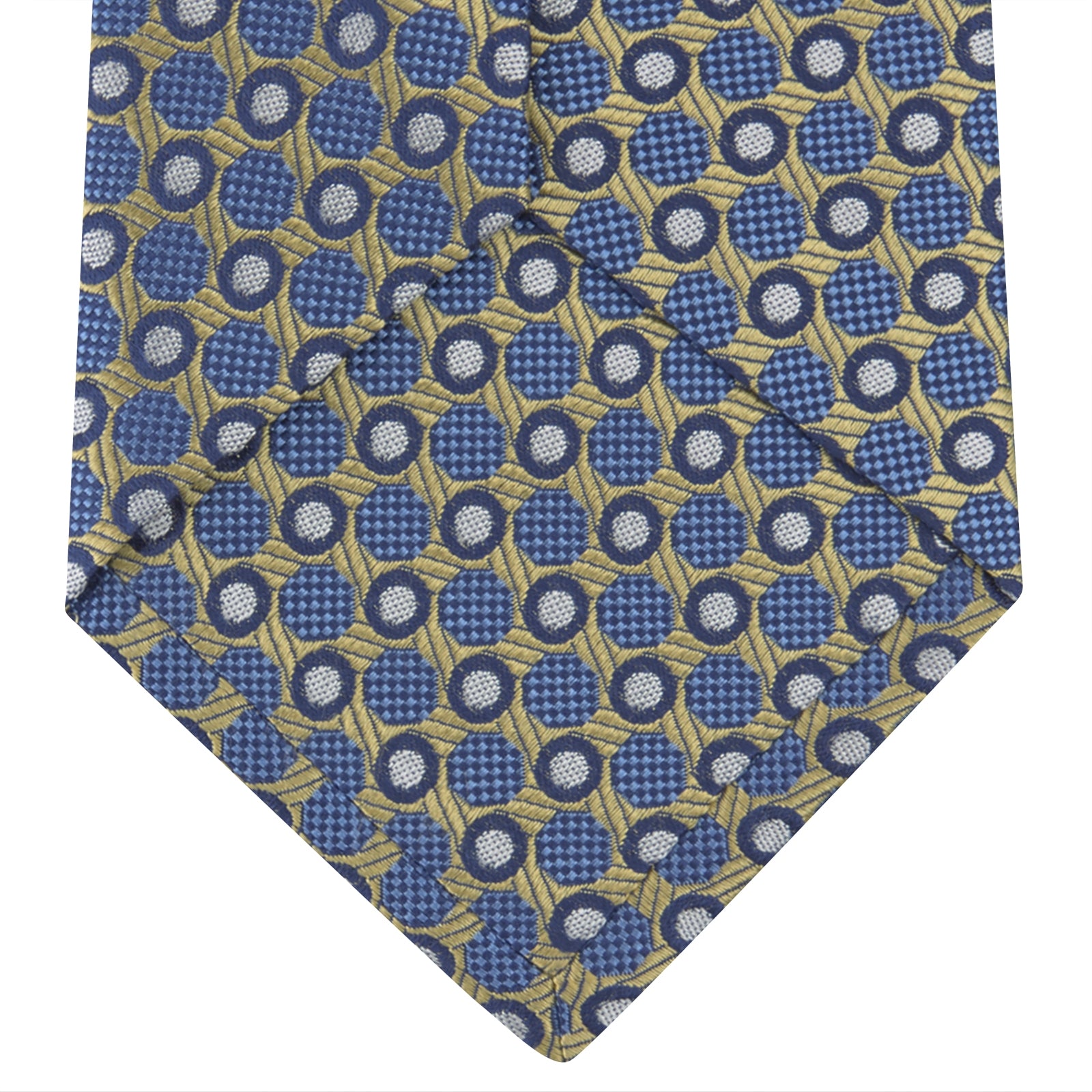 View 4 of product The Gold and Blue Circle and Spot Silk Tie by Turnbull & Asser features blue silk adorned with yellow and white circles and lines, rolled neatly on a light background—an elegant choice for complementing any office shirt.