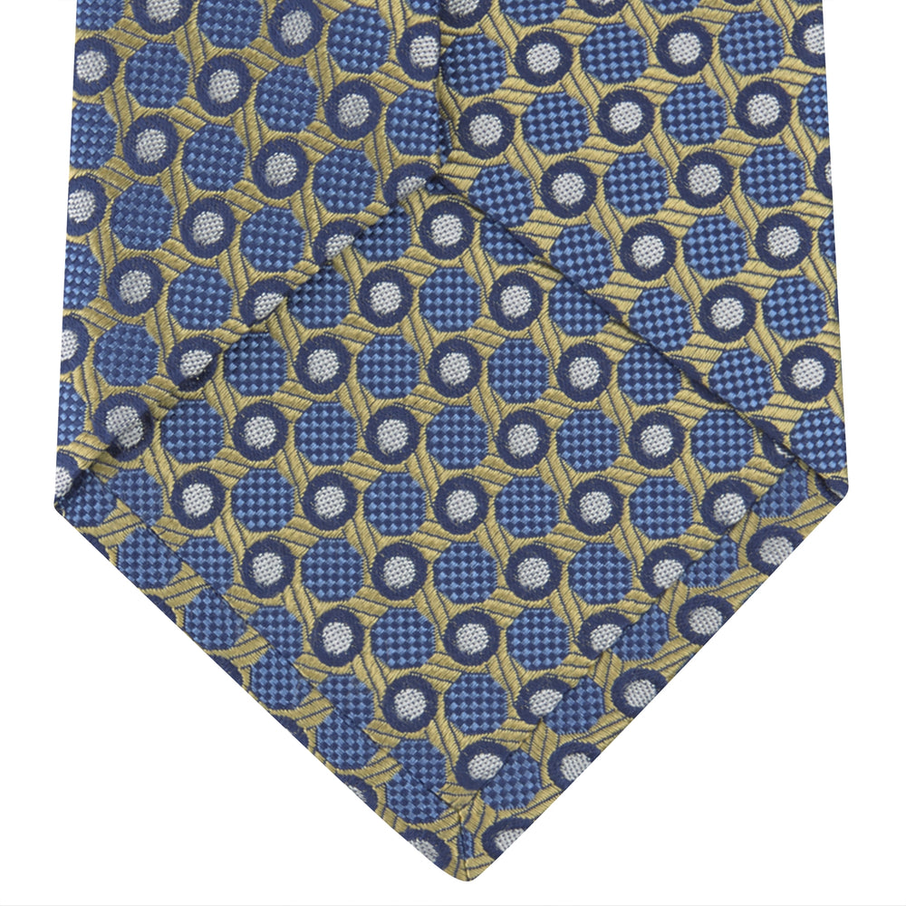 The Gold and Blue Circle and Spot Silk Tie by Turnbull & Asser features blue silk adorned with yellow and white circles and lines, rolled neatly on a light background—an elegant choice for complementing any office shirt.