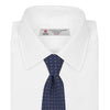 View 2 of product The Turnbull & Asser Navy Floral Spot Silk Tie, featuring a subtle light blue and gray pattern, is rolled up against a plain white background—an ideal accessory for any office shirt.