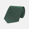 View 1 of product The Turnbull & Asser Green Floral Spot Silk Tie features small, light-colored circular dots on a classic green silk background—ideal for dressing up your favorite office shirt. Displayed rolled on a plain white backdrop.