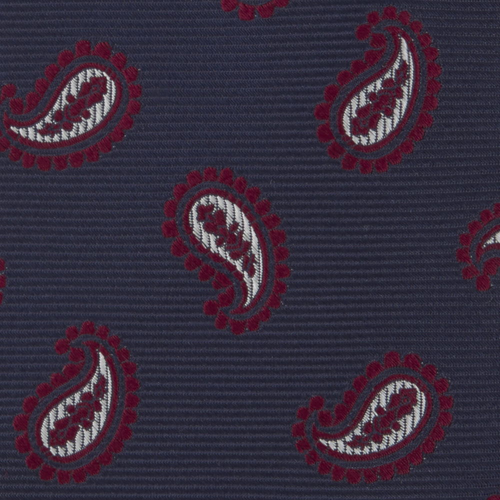 The Turnbull & Asser Navy and Burgundy Floating Paisley Silk Tie is shown rolled up, displaying its repeating paisley design on a plain white background.