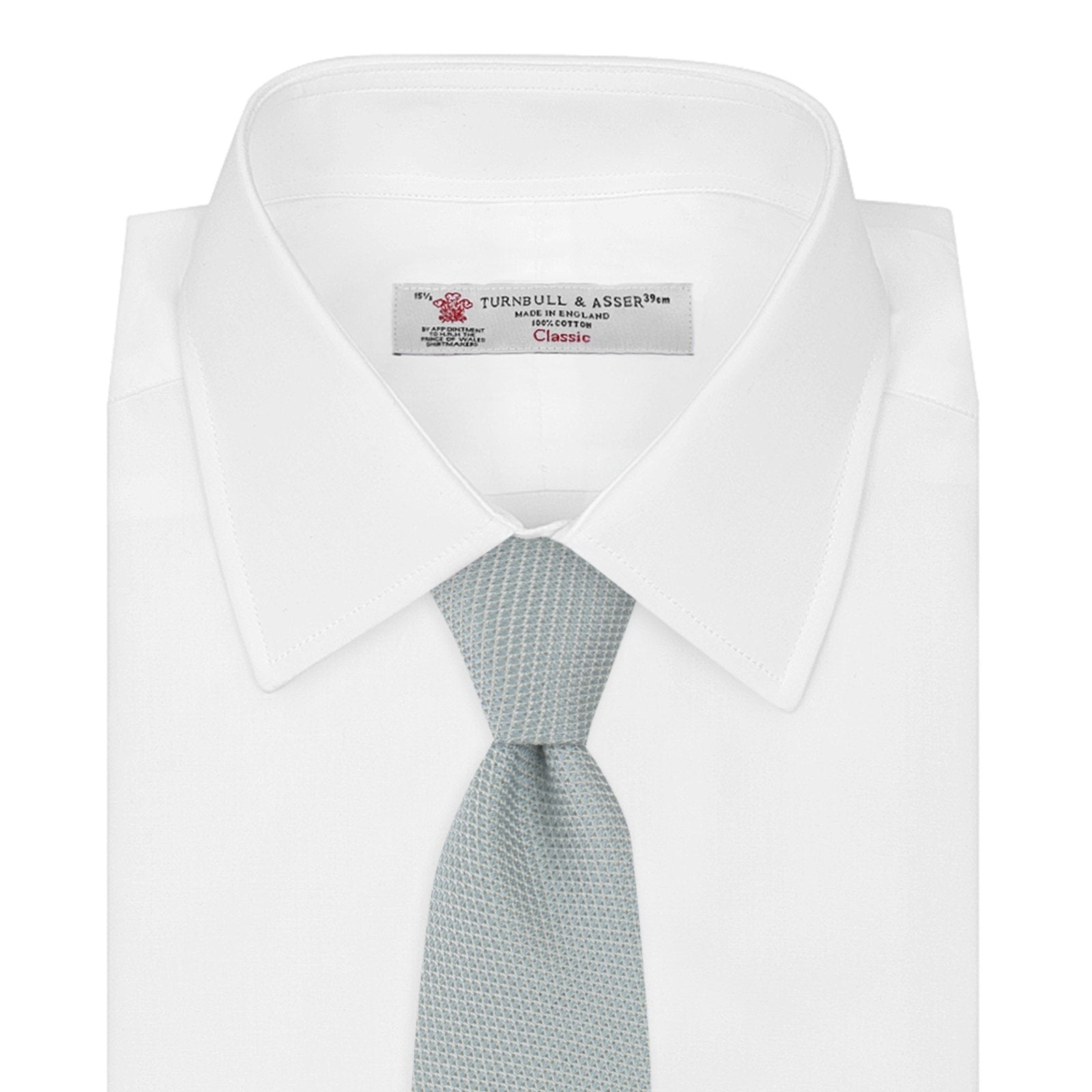 View 2 of product A neatly rolled Turnbull & Asser Light Blue Grenadine Silk Tie, featuring a subtle textured weave, displayed on a white background.