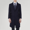 View 2 of product The Turnbull & Asser Navy Lambswool Joseph Overcoat, a men's knee-length coat with notched lapels, a single-breasted front, and three flap pockets per side, is shown against a plain white background.