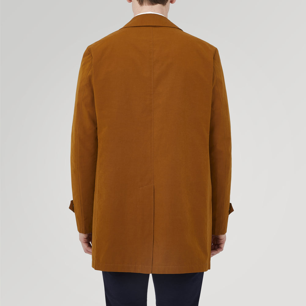 The Turnbull & Asser Dark Khaki Cotton Car Coat features a classic collar, long sleeves, front welt pockets, tailored fit, and concealed button closure in a knee-length modern design, shown against a plain white background.