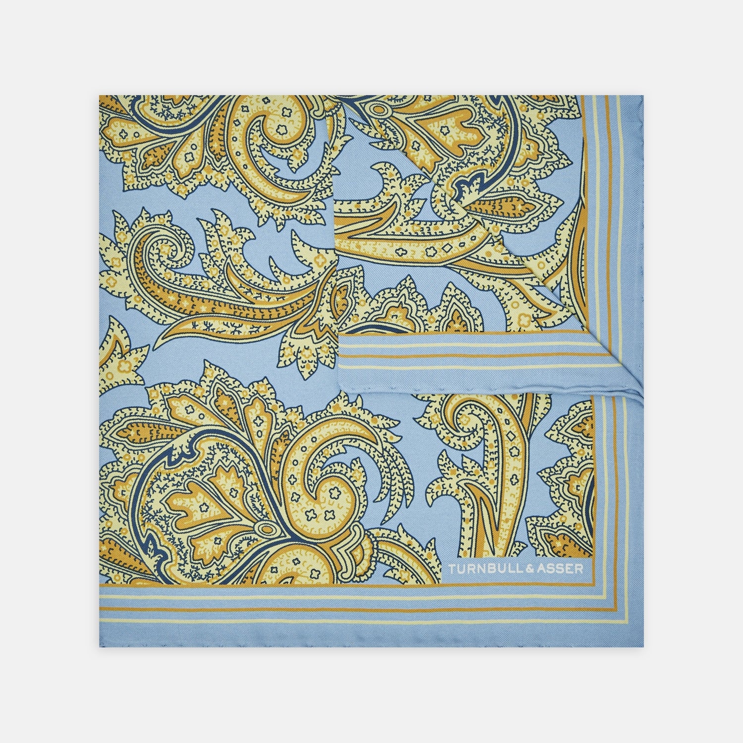 View 1 of product A folded Light Blue and Yellow Large Paisley Silk Pocket Square by Turnbull & Asser features an intricate paisley design. The brand name appears in white on the bottom right corner.