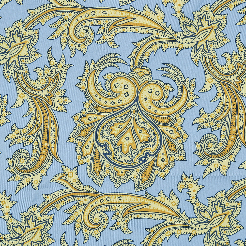 A folded Light Blue and Yellow Large Paisley Silk Pocket Square by Turnbull & Asser features an intricate paisley design. The brand name appears in white on the bottom right corner.
