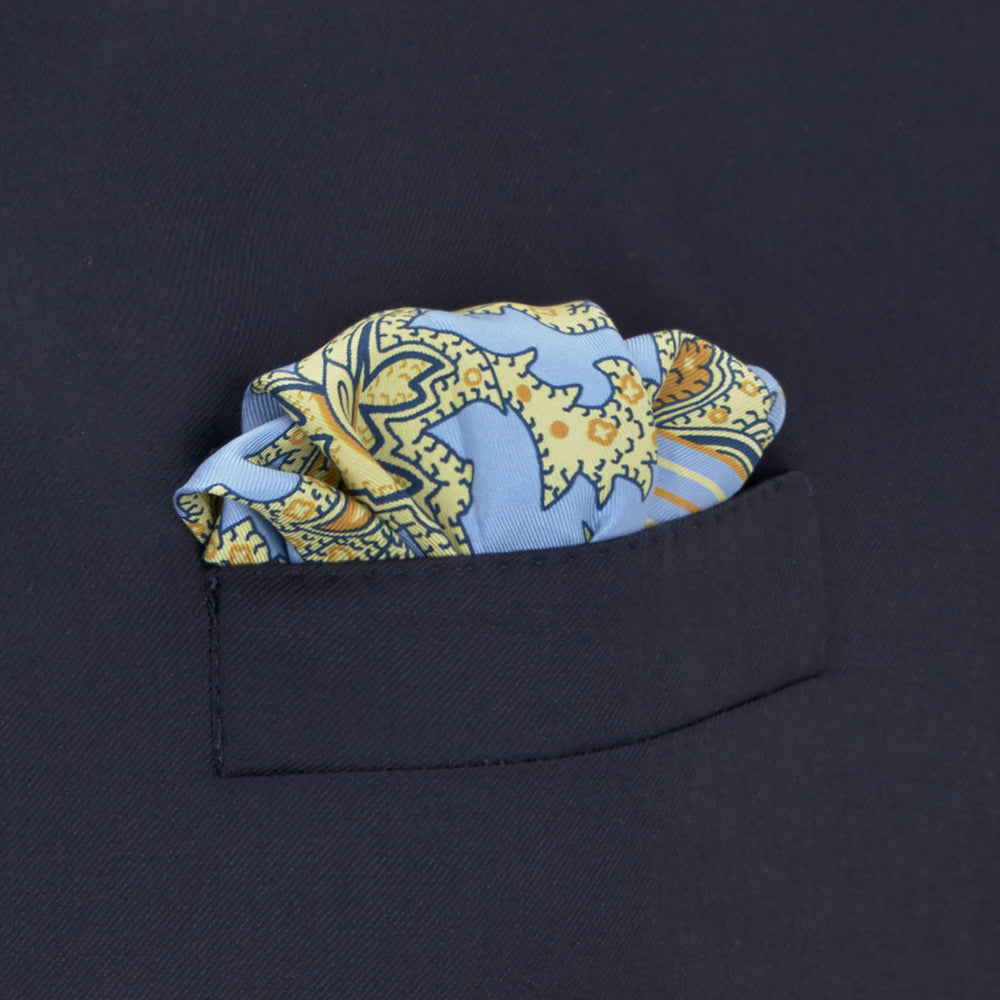 A folded Light Blue and Yellow Large Paisley Silk Pocket Square by Turnbull & Asser features an intricate paisley design. The brand name appears in white on the bottom right corner.