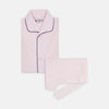 View 1 of product The Turnbull & Asser Pink Piped Cotton Pyjama Set, featuring dark piping on the collar and front with matching pants, is elegantly displayed on a white background—a luxurious sleepwear choice.