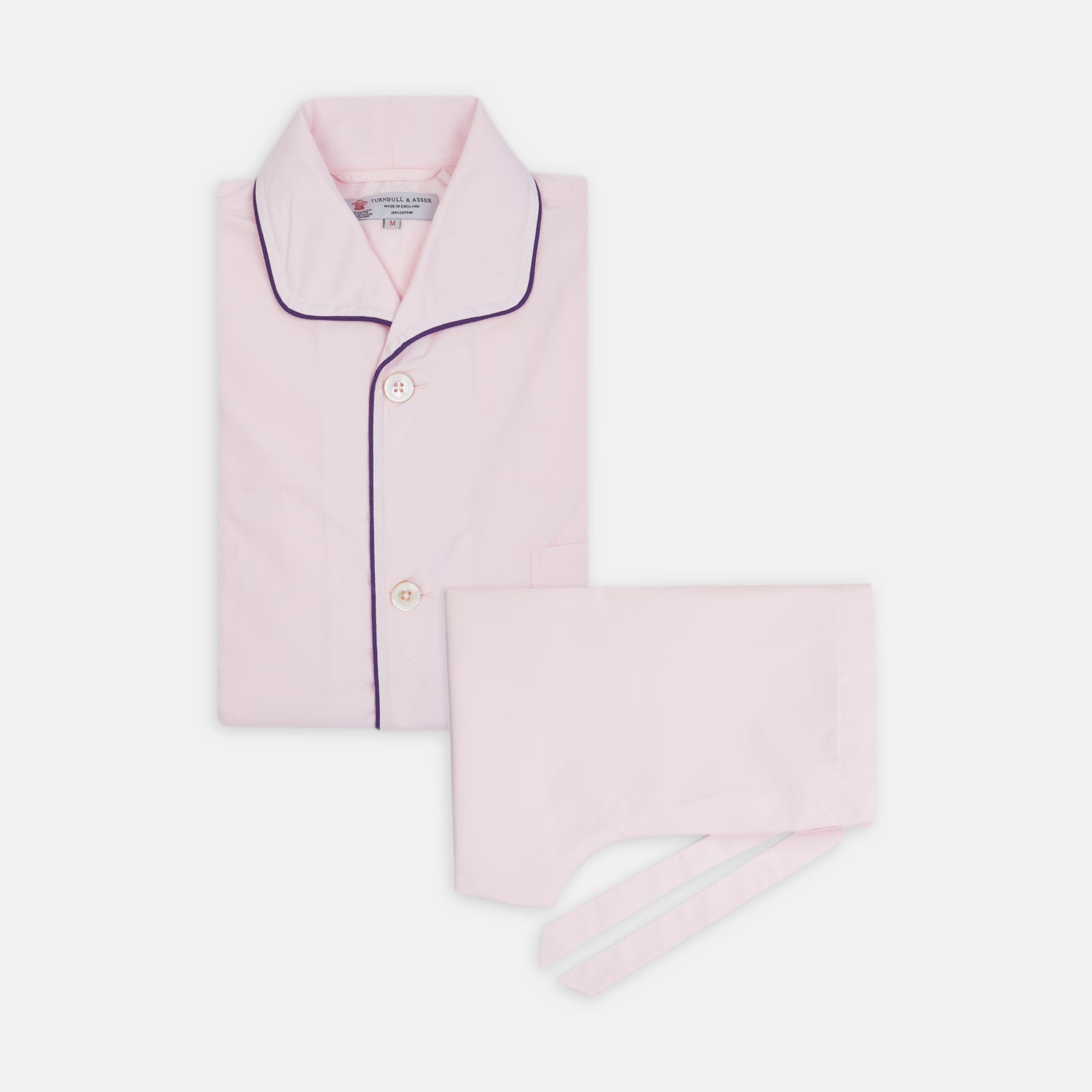 View 1 of product The Turnbull & Asser Pink Piped Cotton Pyjama Set, featuring dark piping on the collar and front with matching pants, is elegantly displayed on a white background—a luxurious sleepwear choice.