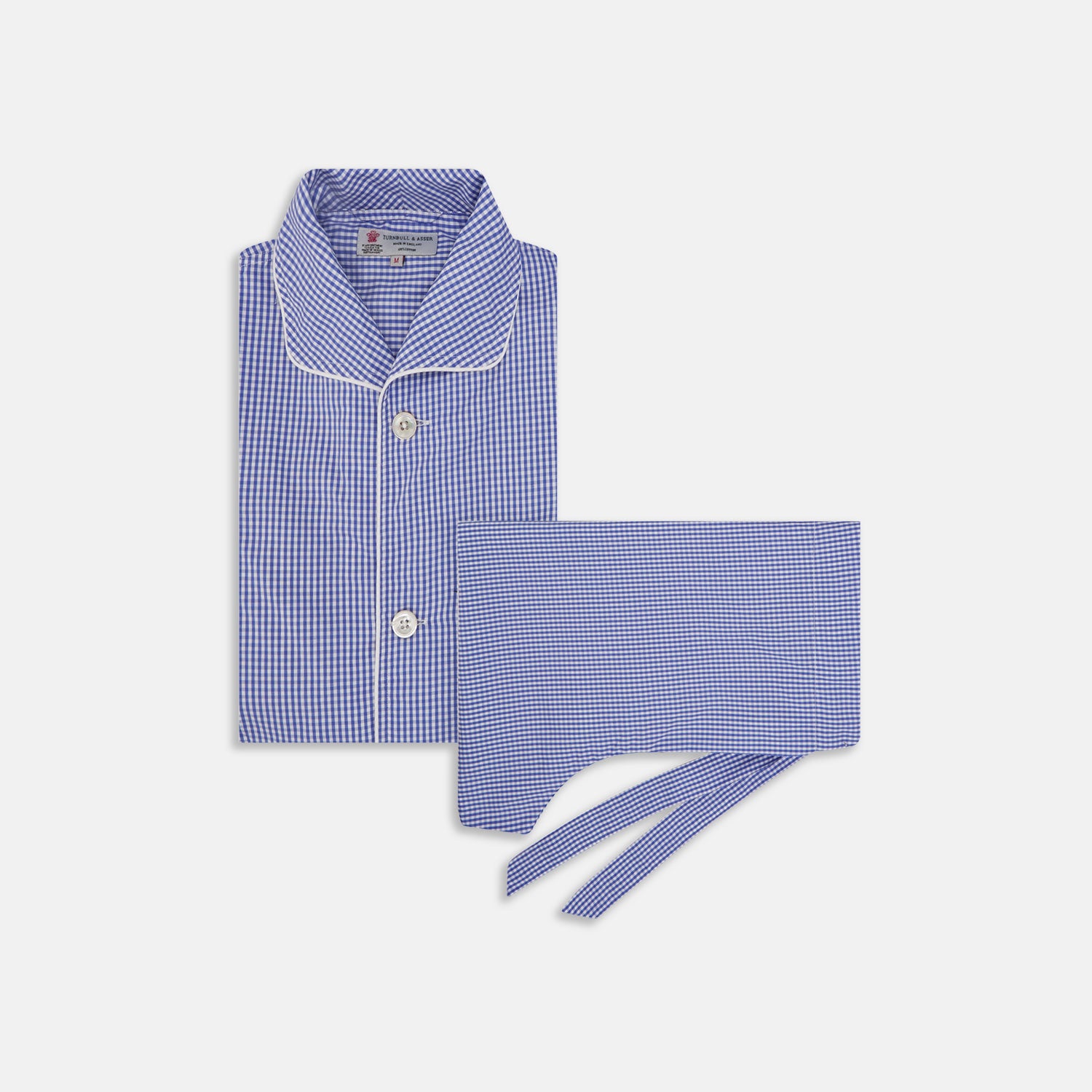 View 1 of product The Turnbull & Asser Mid Blue Gingham Check Piped Cotton Pyjama Set features white piping, two buttons, and a matching fabric belt, displayed on a white background—ideal for lovers of classic luxury sleepwear.