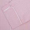 View 2 of product The Turnbull & Asser Pink Bengal Stripe Piped Cotton Pyjama Set features a folded pink and white striped top with white buttons and a matching fabric belt, both displayed flat on a light background.