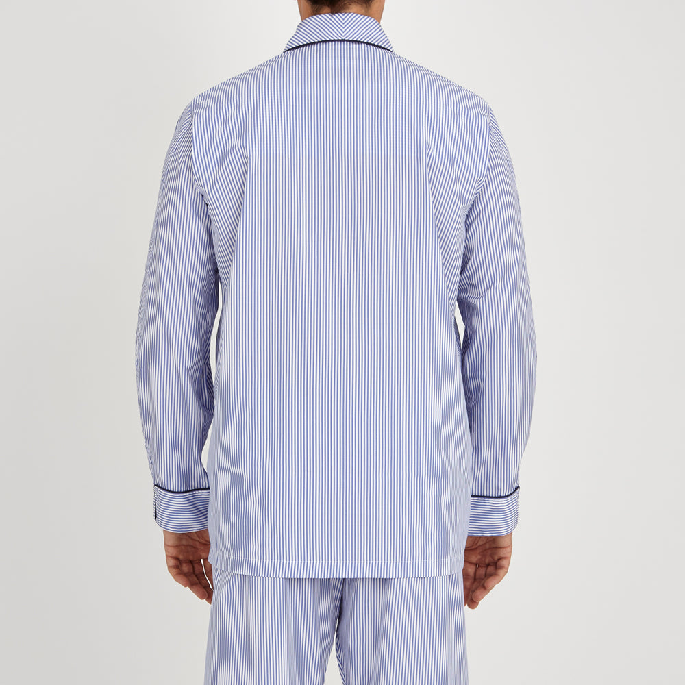 The Turnbull & Asser Blue Bengal Stripe Piped Cotton Pyjama Set, featuring a folded top with white buttons beside matching bottoms, is displayed on a plain light background.