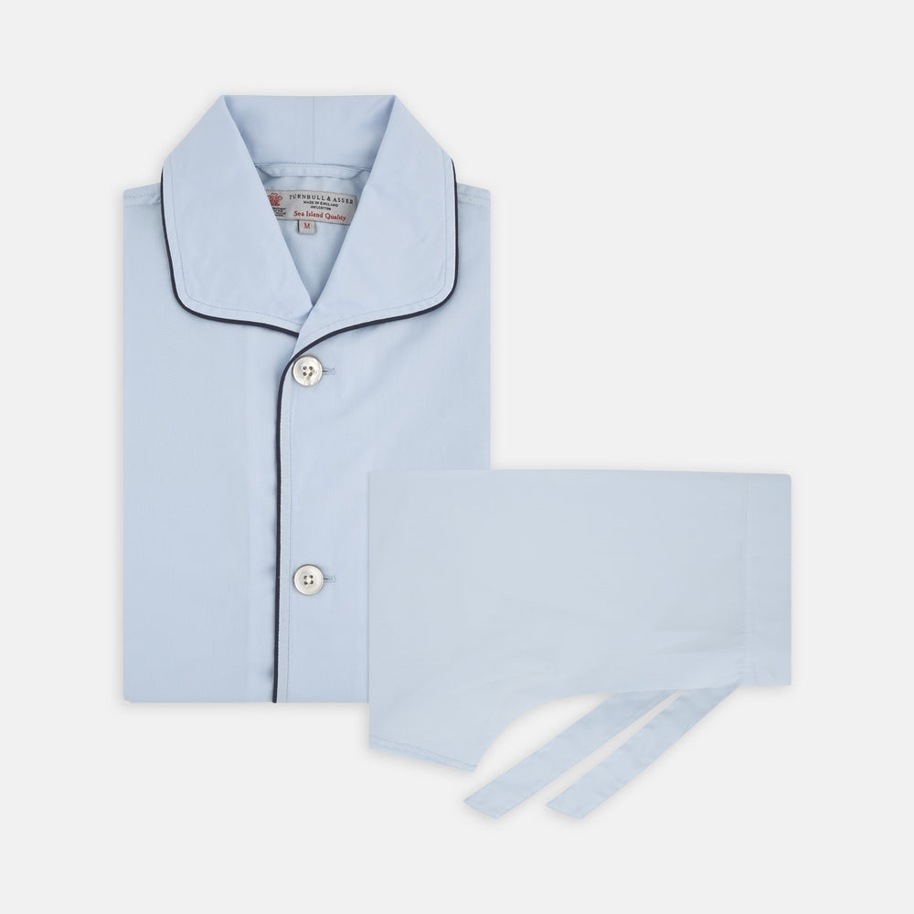 The Light Blue Piped Sea Island Quality Cotton Pyjama Set by Turnbull & Asser, shown with a matching face mask, features dark piping and is crafted from premium cotton, all displayed on a plain white background for a luxurious look.