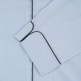 View 2 of product The Light Blue Piped Sea Island Quality Cotton Pyjama Set by Turnbull & Asser, shown with a matching face mask, features dark piping and is crafted from premium cotton, all displayed on a plain white background for a luxurious look.