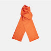View 1 of product The Turnbull & Asser Orange and White Spotted Silk Scarf, featuring white polka dots and fringed edges, is neatly folded and displayed on a plain light gray background.