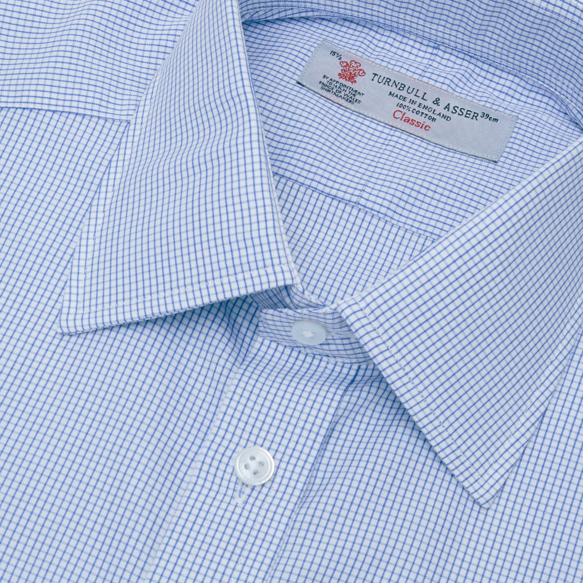 View 5 of product The Turnbull & Asser Blue Grid Check Shirt features a T&A collar, 3-button cuffs, and a refined blue and white grid pattern, displayed against a white background.