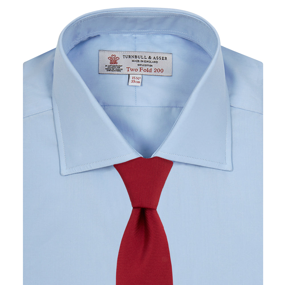A neatly folded Burgundy Corduroy Cotton Shirt by Turnbull & Asser, featuring a Cambridge collar and 3-button cuffs, displayed against a plain white background.