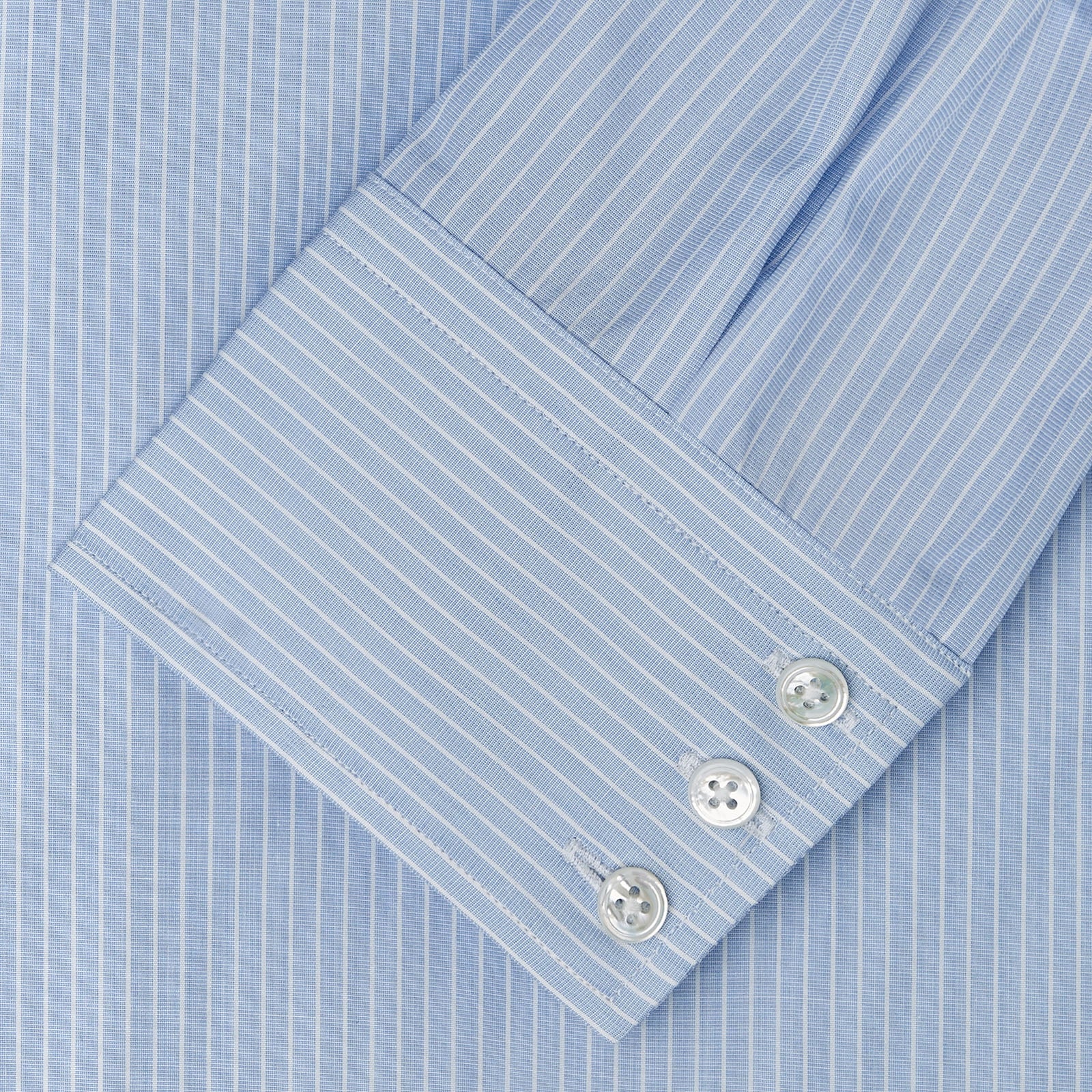 View 3 of product The Turnbull & Asser Tailored Fit Light Blue and White Pinstripe Shirt features a Bury collar and 3-button cuffs, neatly folded and displayed on a plain white background.