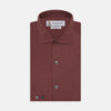 View 1 of product The Turnbull & Asser Tailored Fit Burgundy Cotton Shirt features a classic Kent collar and 2-button cuffs, displayed neatly folded with dark buttons against a plain white background.