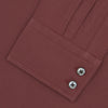 View 2 of product The Turnbull & Asser Tailored Fit Burgundy Cotton Shirt features a classic Kent collar and 2-button cuffs, displayed neatly folded with dark buttons against a plain white background.