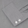 View 2 of product Turnbull & Asser’s Tailored Fit Grey End-On-End Shirt features a classic Kent collar, white buttons, and 2-button cuffs. This long-sleeved shirt is displayed neatly folded against a plain white background.