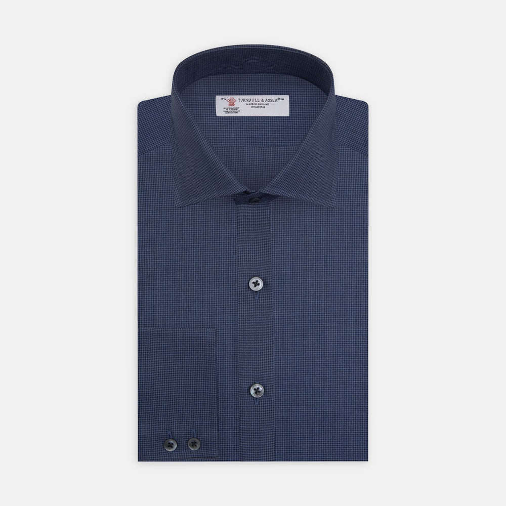 A circular swatch of Turnbull & Asser's Navy Check Flannel Fabric features a small repeating houndstooth pattern in navy blue, set on a white background with a thin gray border.