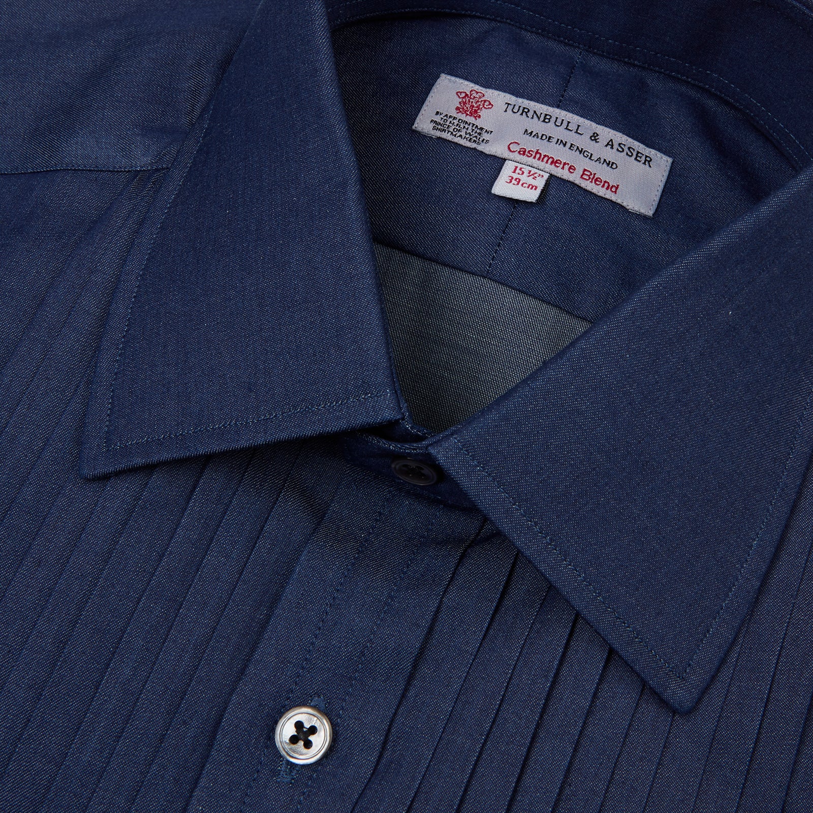 View 4 of product A neatly folded Turnbull & Asser Dark Blue Denim-Cashmere Dress Shirt with T&A collar and 3-button cuffs, showcased on a plain light background, offers a refined formal alternative.