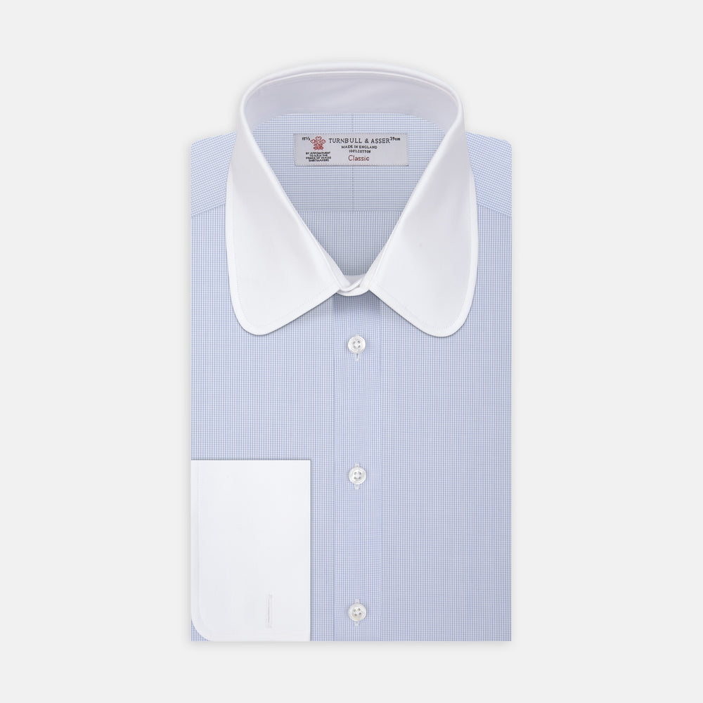 A neatly folded The Great Gatsby Cotton Shirt by Turnbull & Asser, featuring a light blue body, white rounded collar, and double cuffs inspired by 1920s style, displayed on a plain light background.