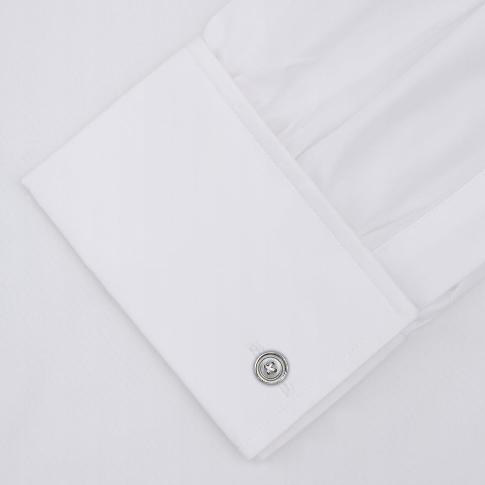 The Turnbull & Asser Two-Fold 120 White Cotton Shirt features long sleeves, a regent collar, double cuffs, and white buttons, neatly displayed against a light blue background.