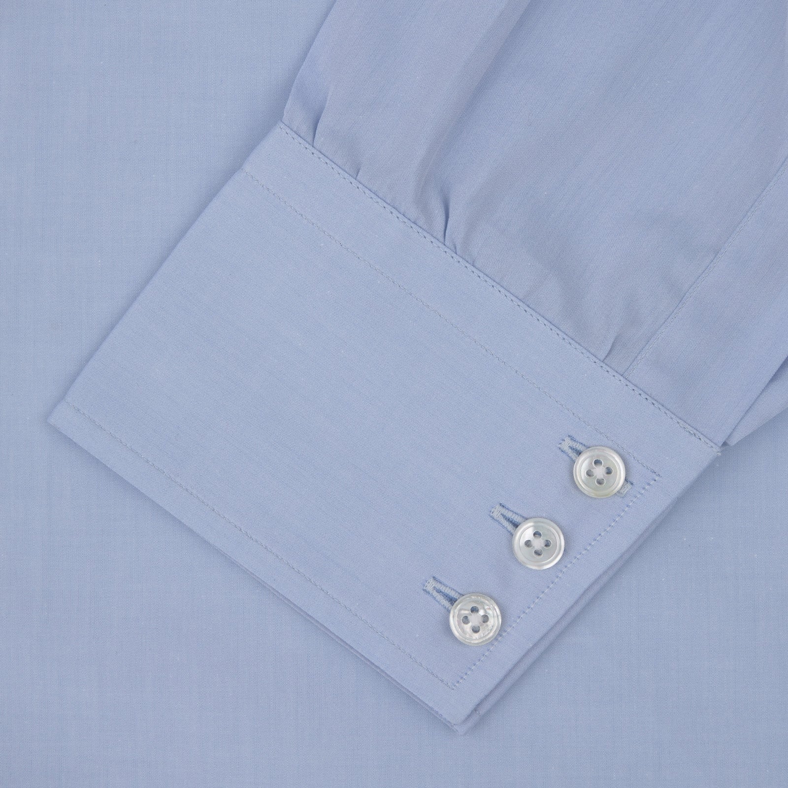View 4 of product The Turnbull & Asser Blue West Indian Sea Island Cotton Shirt features a T&A collar, 3-button cuffs, white buttons, a front chest pocket, and a monogrammed label inside the collar.