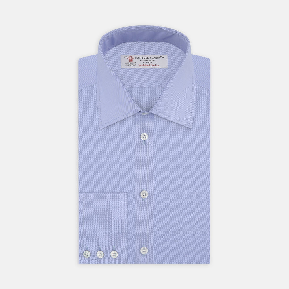 The Turnbull & Asser Blue Sea Island Quality Cotton Twill Shirt features a T&A collar, chest pocket, white buttons, and 3-button cuffs, all showcased on a plain white background.