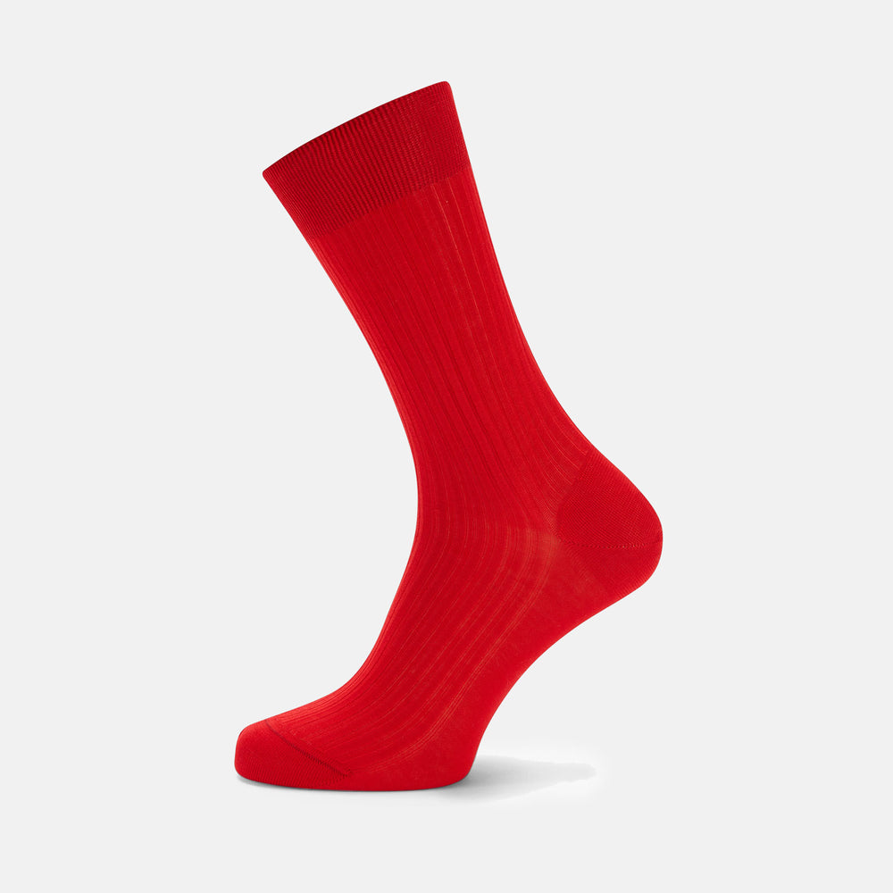 A single Scarlet Short Cotton Sock by Turnbull & Asser, in bright red, stands upright on a light gray background, displaying its side view and ribbed texture.
