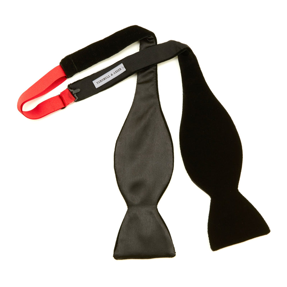 The Turnbull & Asser Black Velvet Bow Tie, shown against a plain white background, is an elegant choice for formal occasions.