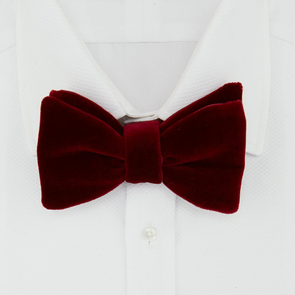 The Turnbull & Asser Burgundy Velvet Bow Tie features a soft, plush texture and is shown on a plain white background—an ideal accessory for formal soirées.