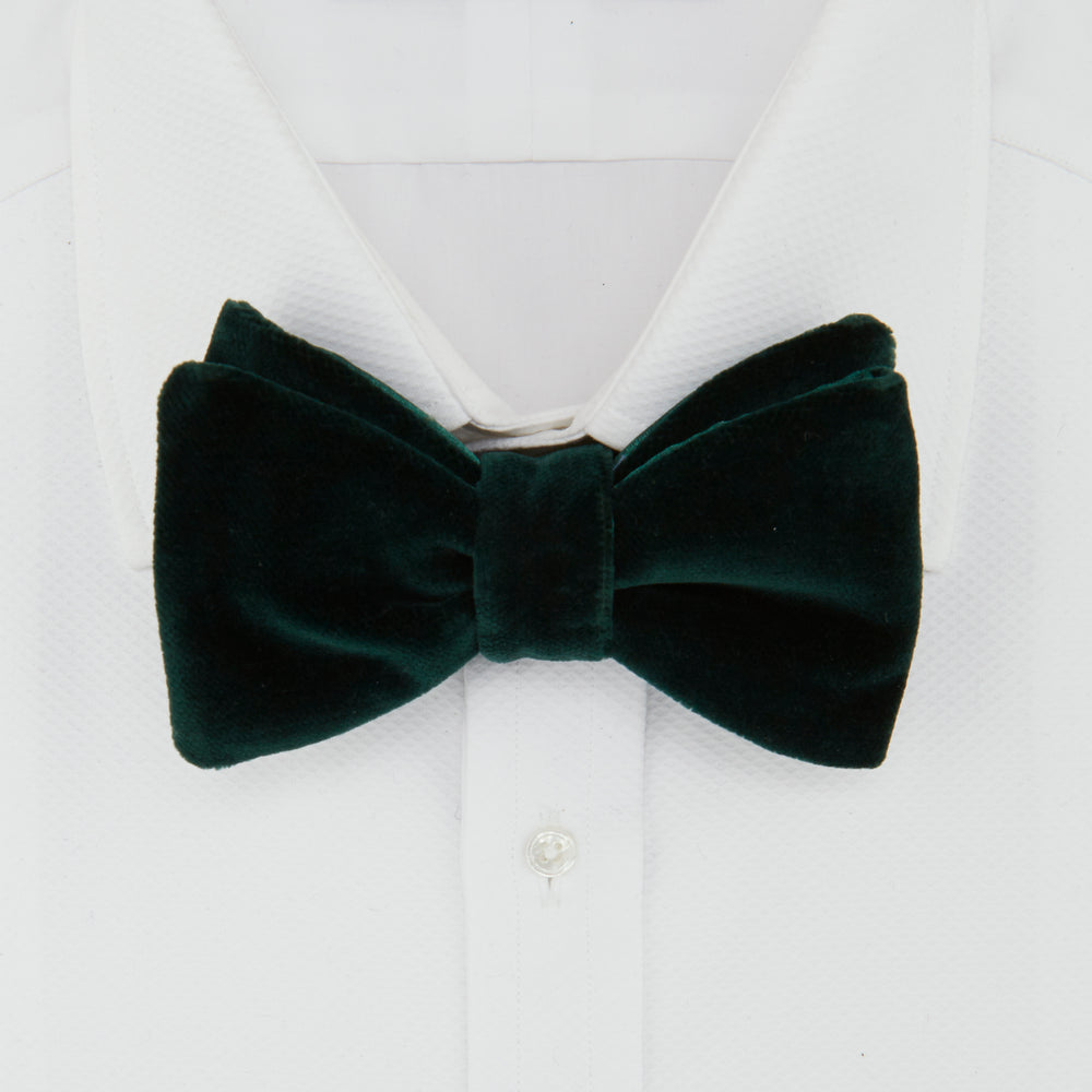 The Turnbull & Asser Green Velvet Bow Tie features a rich dark green hue and plush, smooth texture, ideal for formal events. Shown here against a plain white background.