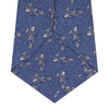 View 4 of product The Blue Carp Silk Tie by Turnbull & Asser features a blue silk base with white and dark blue koi fish among light blue swirls. The tie is displayed rolled up, pointed end forward.