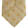 View 4 of product The Turnbull & Asser Soft Yellow Floral Jacquard Stripe Silk Tie features a rolled-up beige design with subtle texture and small yellow floral patterns evenly spaced throughout.