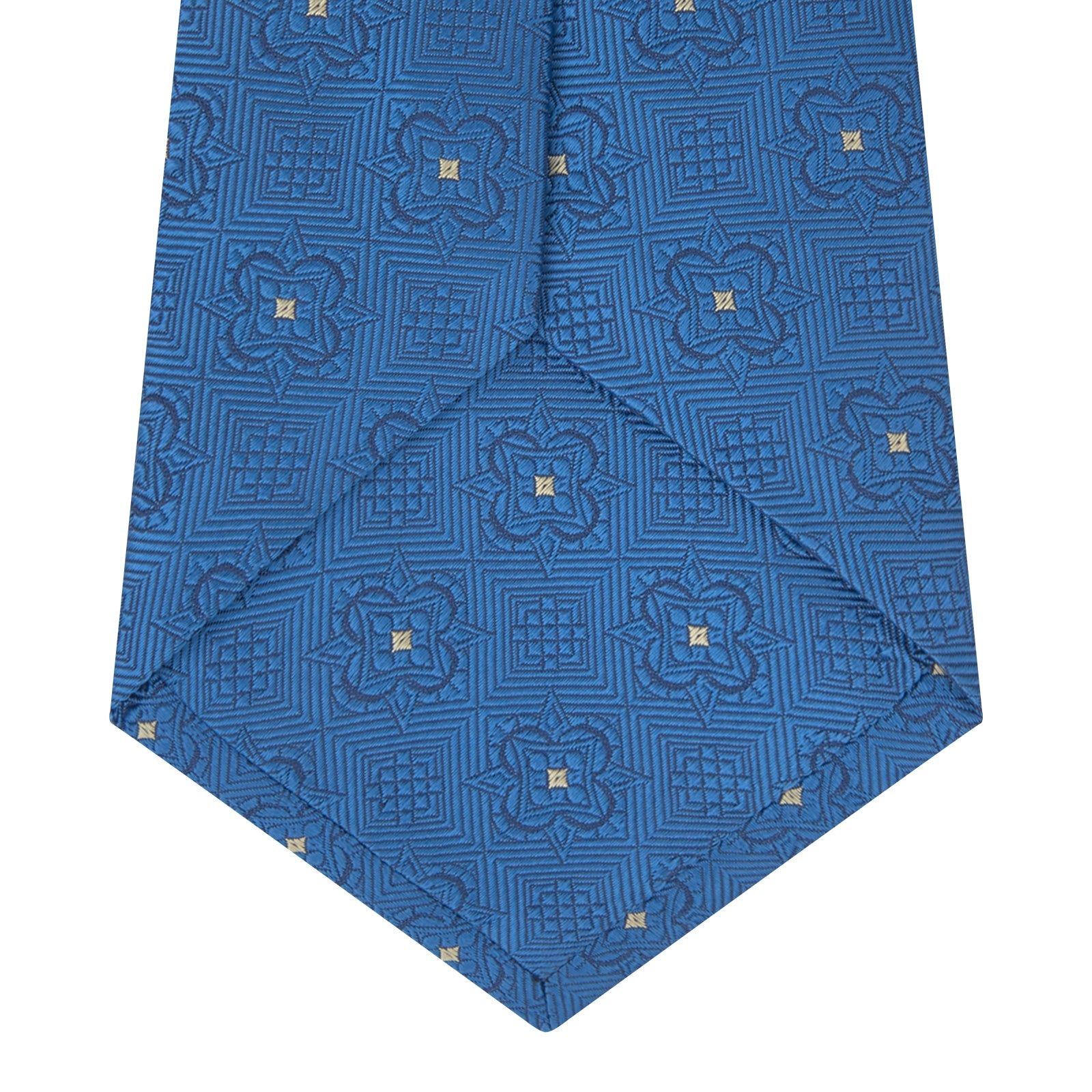View 4 of product The Turnbull & Asser Blue Flower Mosaic Silk Tie features a blue silk fabric with a detailed geometric and floral design, accented in lighter blue and white, displayed on a white background.