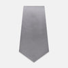 View 2 of product The Grey Satin Silk Tie by Turnbull & Asser is displayed vertically against a white background—its solid light grey silk and satin finish make it an elegant choice for a spring wedding.