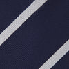 View 3 of product The Turnbull & Asser Seven-Fold Navy and White Blazer Stripe Repp Silk Tie, elegantly rolled at one end, is displayed on a plain white background.