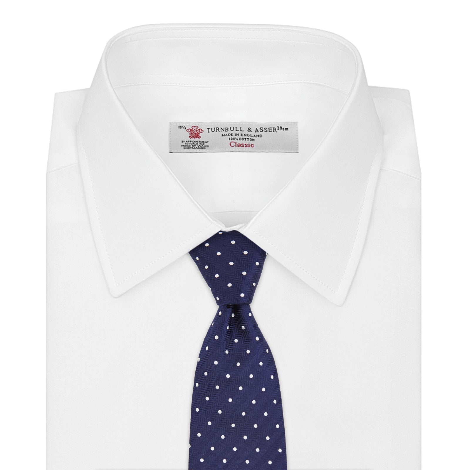 View 2 of product The Turnbull & Asser Slim Navy & White Spot Herringbone Silk Tie features a subtle texture and white polka dots, making it a refined men's accessory. Shown rolled-up on a plain white background.