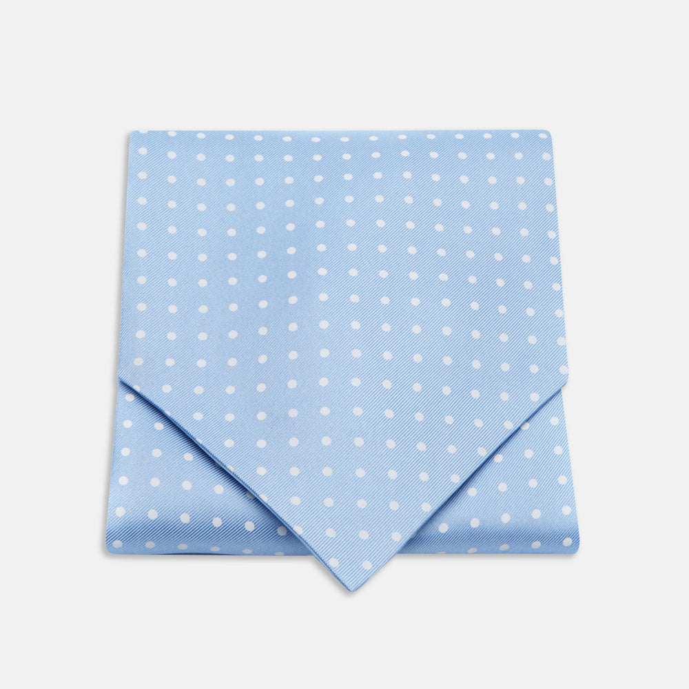 The Turnbull & Asser Sky Blue and White Medium Spot Silk Ascot Tie, neatly folded against a white background, is stylish neckwear—perfect for any wedding guest.
